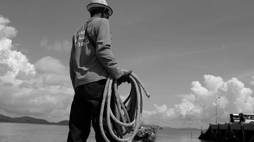 Woman standing by sea against sky