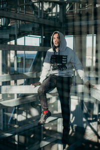 Portrait of young man standing against railing