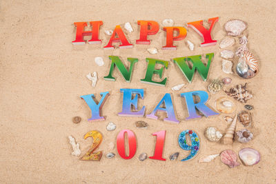 Happy new year text on sand