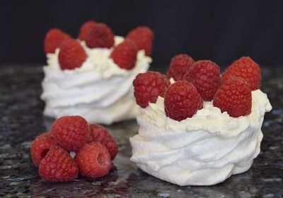 Close-up of raspberry fruits and meringue on table