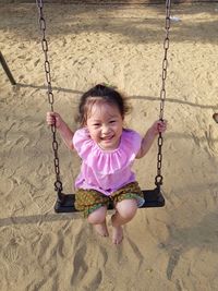 Portrait of cute girl swinging at playground