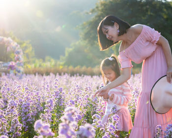 Close-up of mother and daughter by purple flowering plants