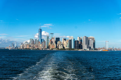 Sea and buildings against blue sky