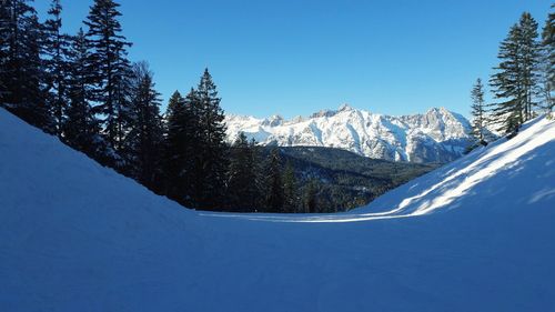 Scenic view of snowcapped mountains against clear blue sky