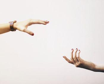 Cropped image of hand holding over white background