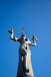 Low angle view of statue against blue sky