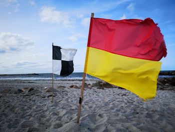 Flag on beach against sky