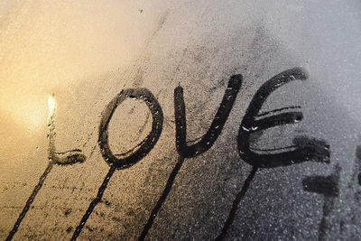 Close-up of love text on condensed glass