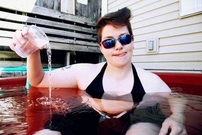 Woman with sunglasses enjoying in bathtub outdoors