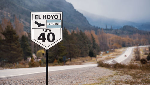 Road sign against trees