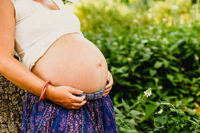 Midsection of woman touching outdoors