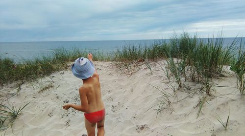 Rear view of a boy standing on beach