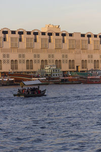 Boats in sea against buildings in city