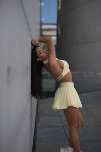 Full length of woman standing against wall