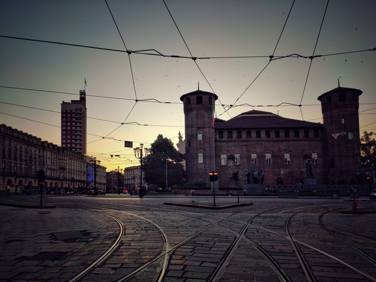 RAILROAD TRACKS AMIDST BUILDINGS IN CITY AGAINST SKY