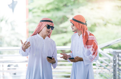 Business colleagues wearing traditional clothing while standing outdoors