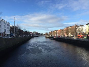 River amidst buildings in city against sky