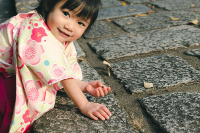 Portrait of cute girl playing on footpath