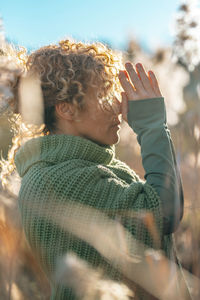 Side view of young woman looking through binoculars