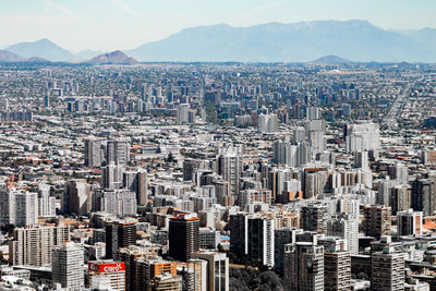 Aerial view of buildings in city against sky