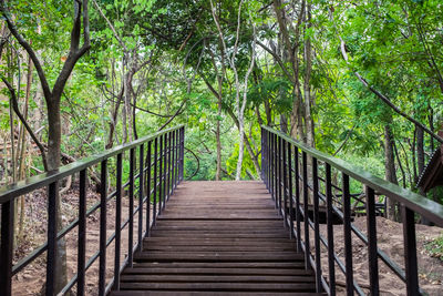 Rear view of man walking on footbridge