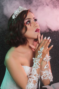 Beautiful young woman sitting with arms raised