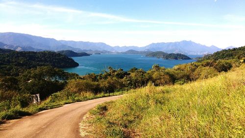 Scenic view of lake and mountains against blue sky