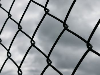 Full frame shot of chainlink fence against cloudy sky