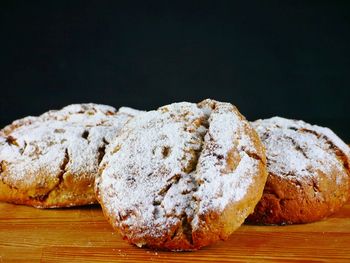 Close-up of bread on table against black background