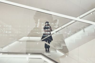 Reflection of woman standing on staircase