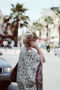 Side view of young woman standing on street