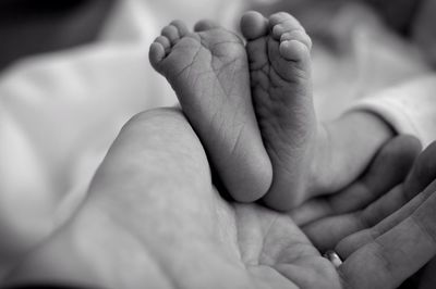 Cropped hand of father touching baby feet