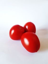 Close-up of red cherries on white background