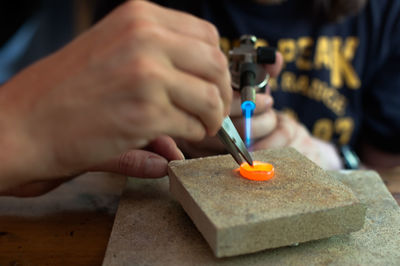 People making wedding ring on table in workshop