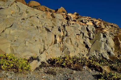 Low angle view of rock formation on land against sky