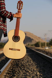 Man playing guitar against the sky