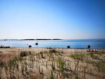 Scenic view of beach against clear blue sky