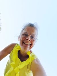 Portrait of smiling woman against sky