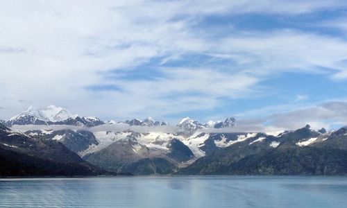 Scenic view of snowcapped mountains against cloudy sky