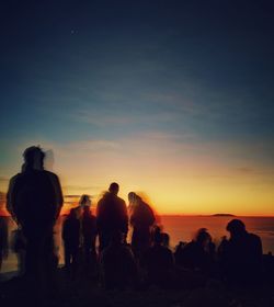 Silhouette people standing against sky during sunset