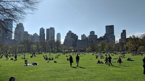 Group of people in park against buildings in city