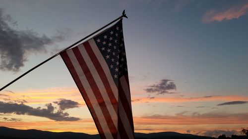 American flag against sky during sunset