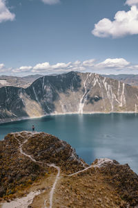 Scenic view of lake by mountains against sky