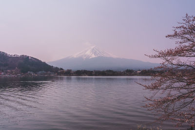 Scenic view of lake by snowcapped mountain against sky