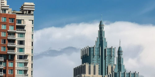 Low angle view of buildings against cloudy sky