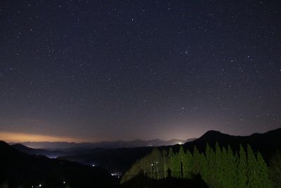 Scenic view of mountains against star field in sky at night