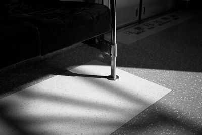 Close-up of metallic stand on tiled floor in train
