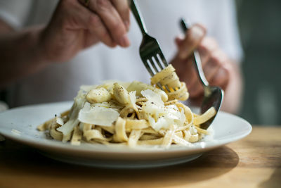 Close-up of person preparing food in plate