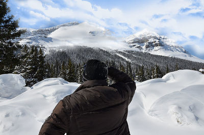 Rear view of snowcapped mountains against sky