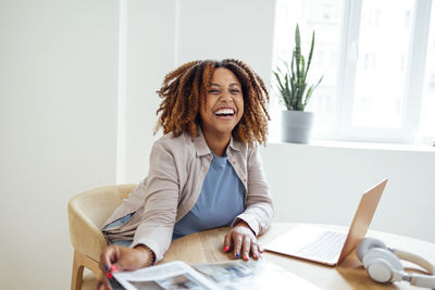 Portrait of young woman using laptop at home